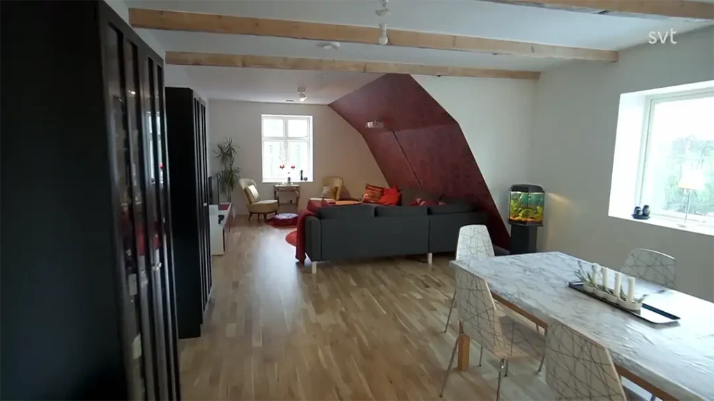 Stiligt - En modern vardagsrums- och matplats med öppen planlösning inspirerad av Bara - Husdrömmar, med trägolv, grå soffa, matbord med stolar, akvarium och stora fönster som fyller utrymmet med naturligt ljus.