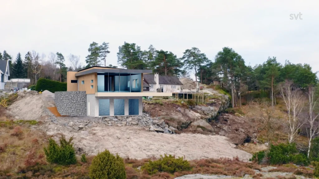 Stiligt - Ett modernt tvåvåningshus med stora fönster ligger på en klippig sluttning i Bohuslän, omgivet av träd och andra bostäder — en sann Husdrömmar som vaknar till liv.