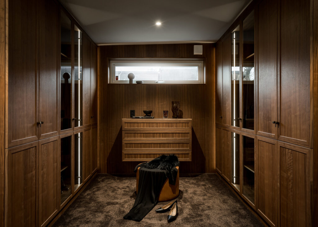 Stylish - A classic walk-in closet with wooden cabinets and a black shoe.