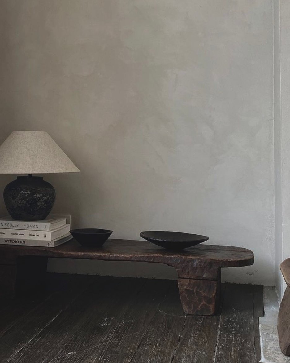 Stylish - A wooden bench in a room with a lamp on it, designed with exquisite interior design.