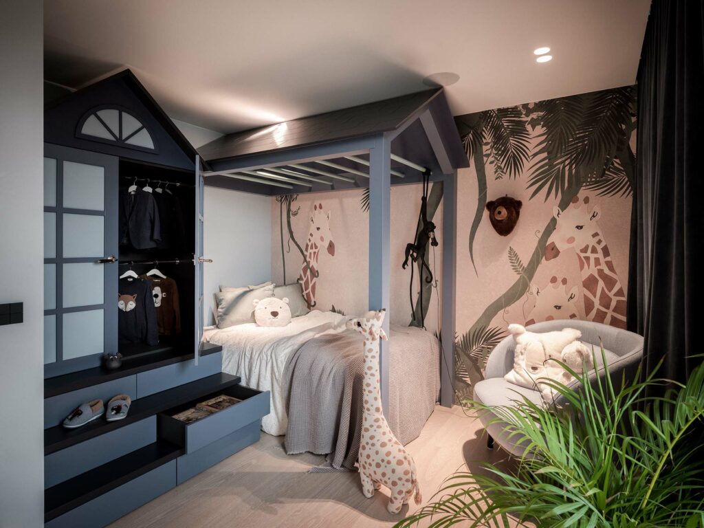 Stylish - Children's bedroom with a stylish house-shaped bed, animal-themed wallpaper, plush toys and a chair. The decor includes plants and a stuffed giraffe.