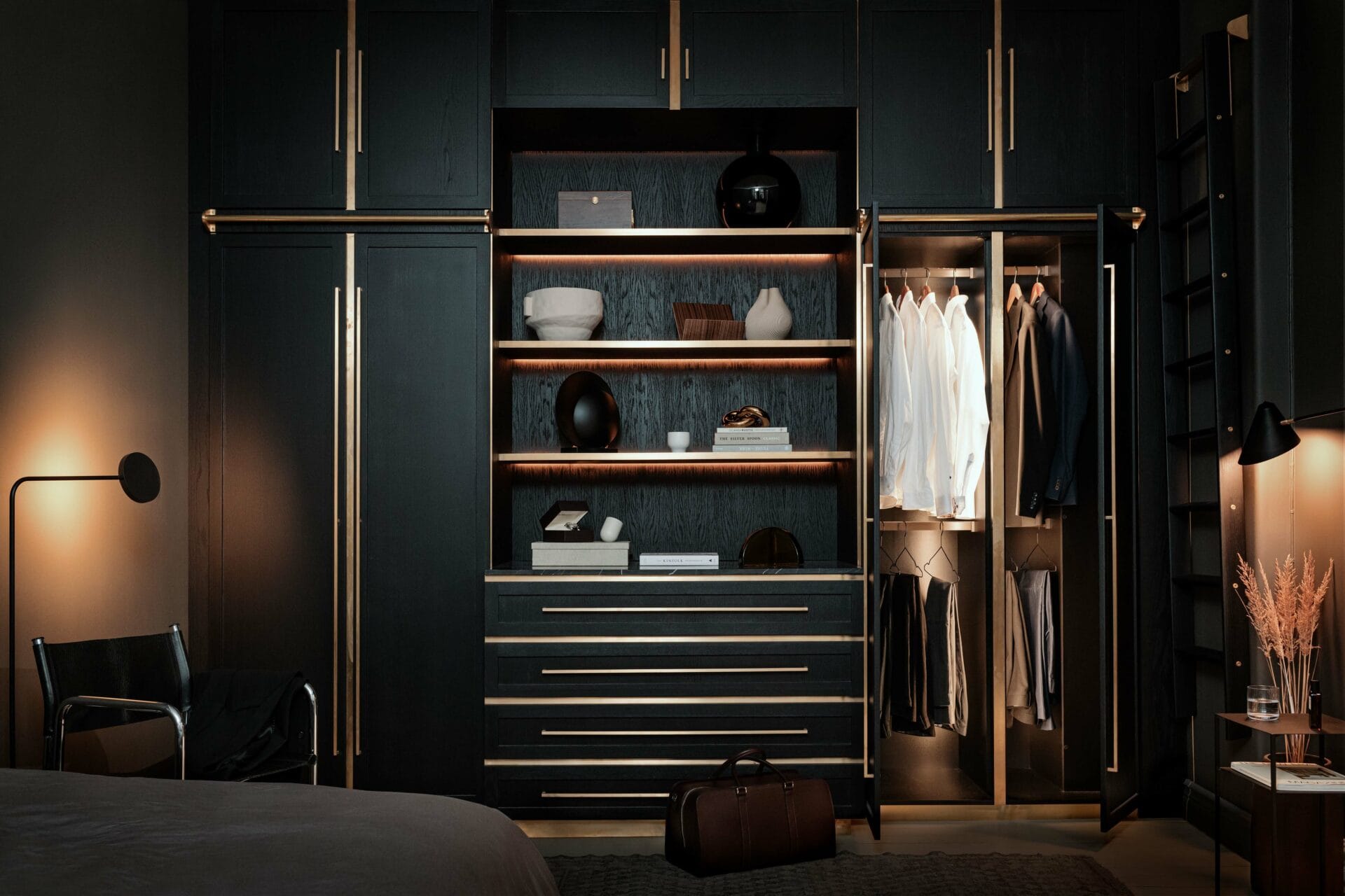 Stylish - A stylish, organized bedroom wardrobe with open shelves displaying neatly arranged stylish shirts, shoes and accessories. Warm lighting provides a cozy atmosphere.