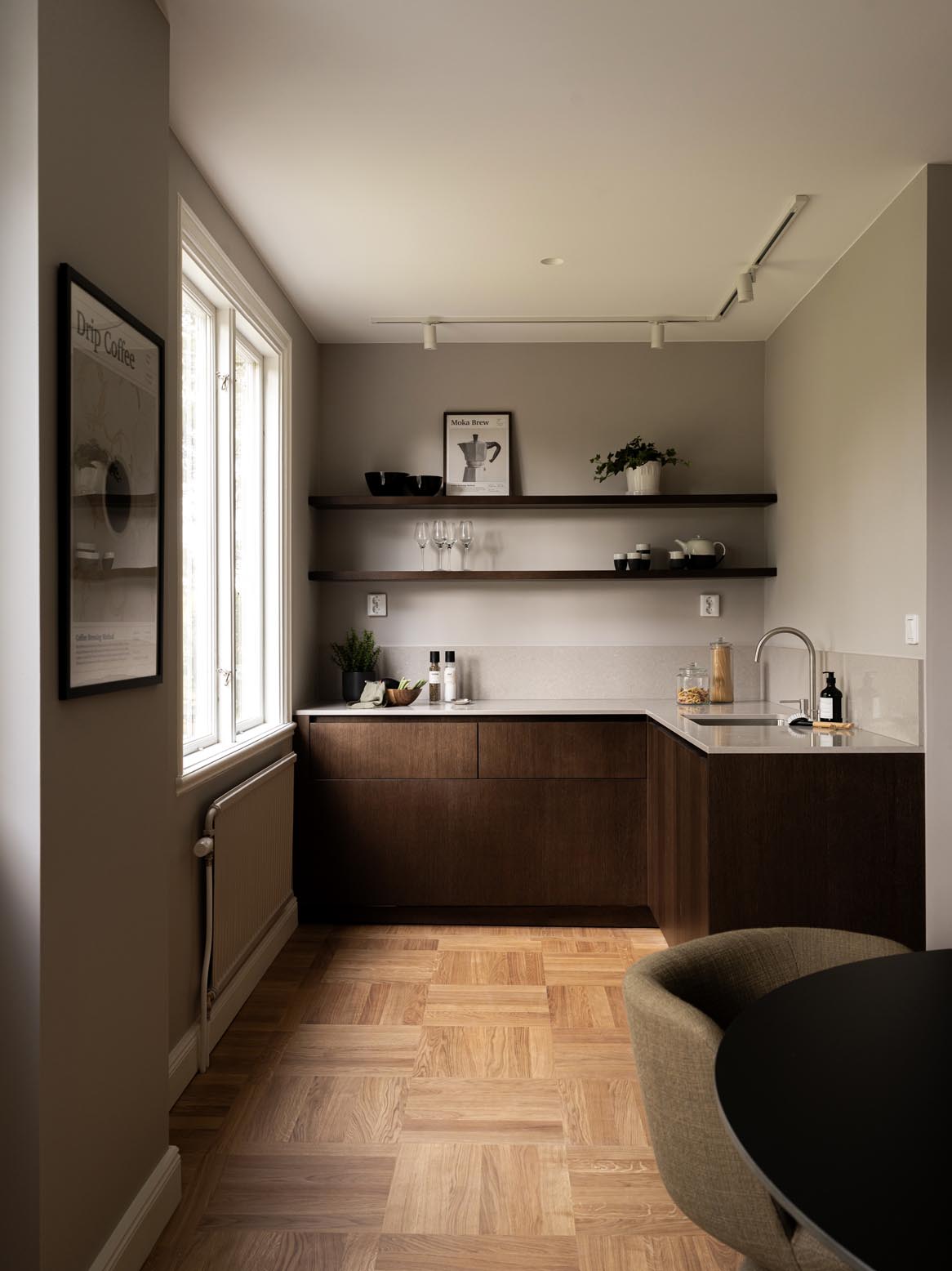 Stiligt - Minimalistisk träkök med pocketdörrar, träskåp, öppna hyllor för inredning och disk, ett handfat och ett stort fönster som översvämmer utrymmet med naturligt ljus. Har en neutral färgpalett och eleganta parkettgolv.