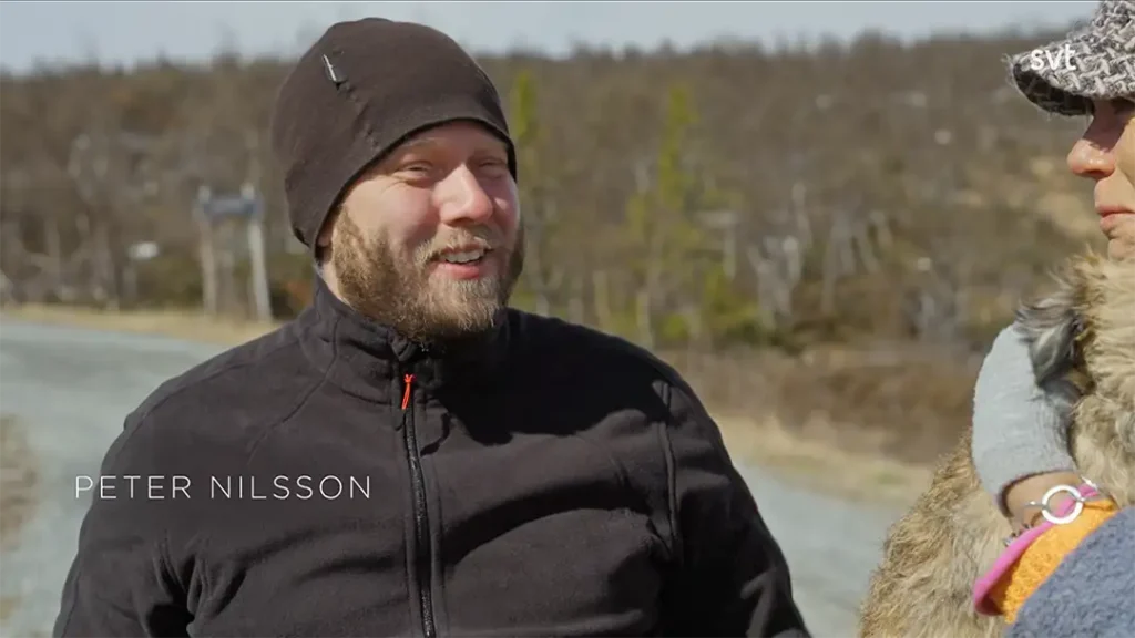 Stiligt - En man i svart hatt och jacka står utomhus bredvid en annan person på en grusväg i Ljungdalen, med träd i bakgrunden. Text på bilden lyder "Peter Nilsson – Husdrömmar.